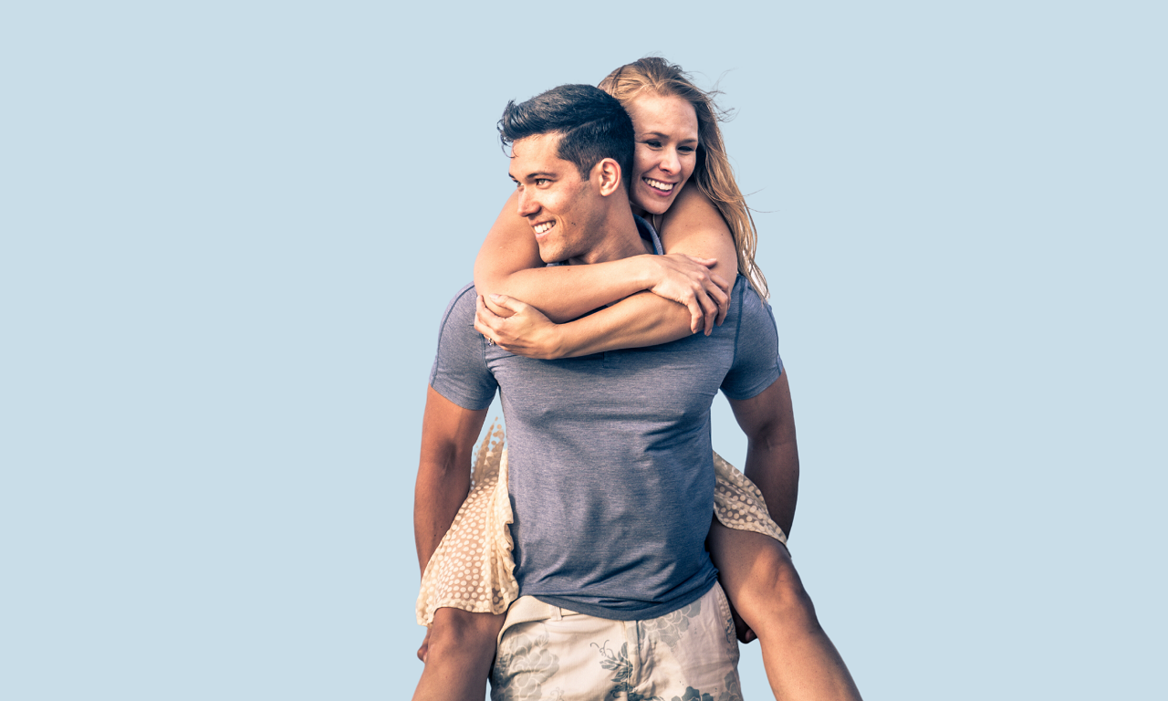 a young couple with beautiful smiles piggy back