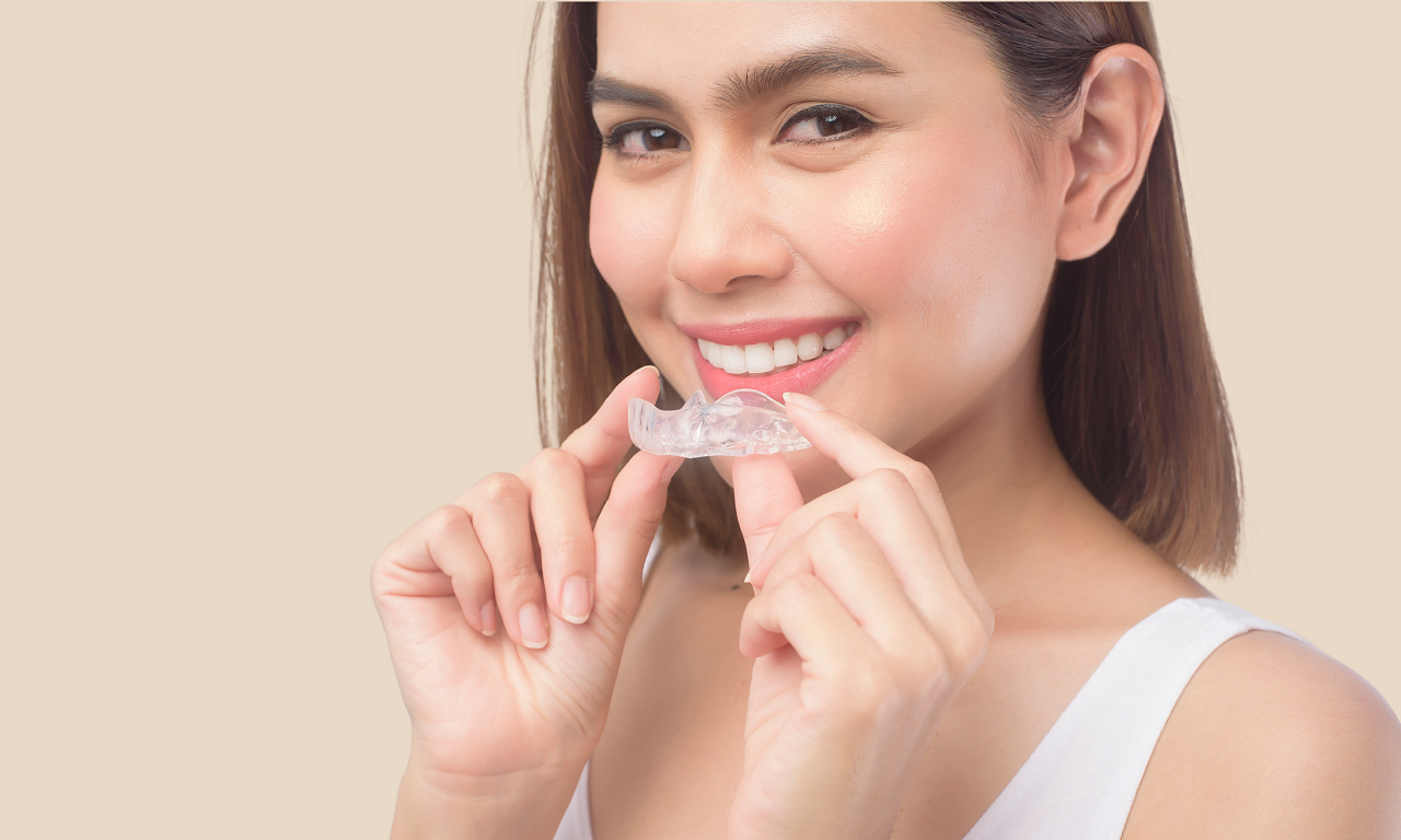 a woman gets ready to put in her Invisalign