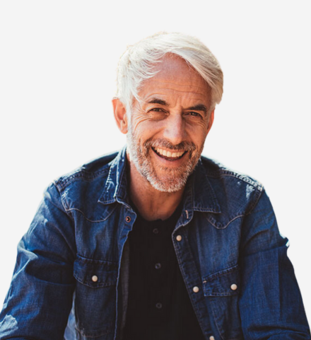 older white man is seated and smiling with a white background