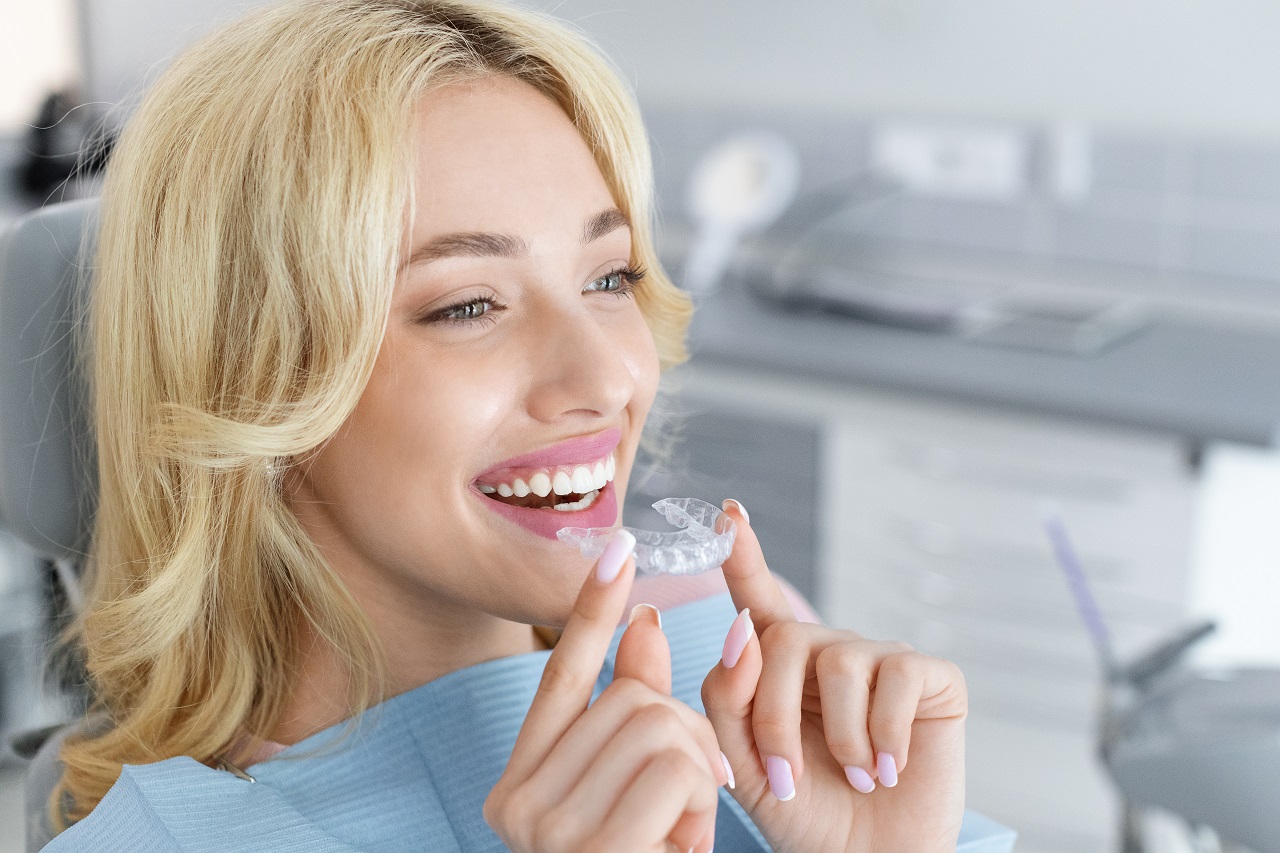 blonde woman puts in Invisalign at a dental clinic