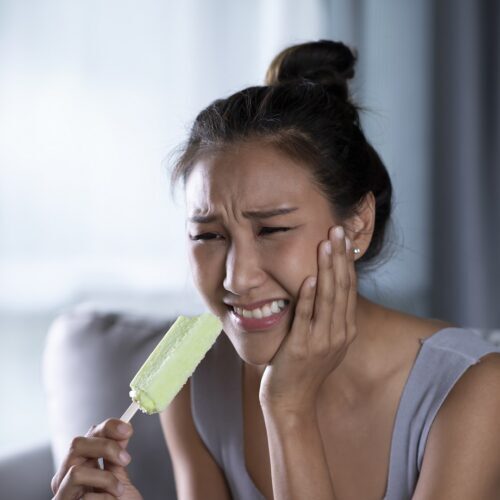 a young asian woman suffers from TMJ 