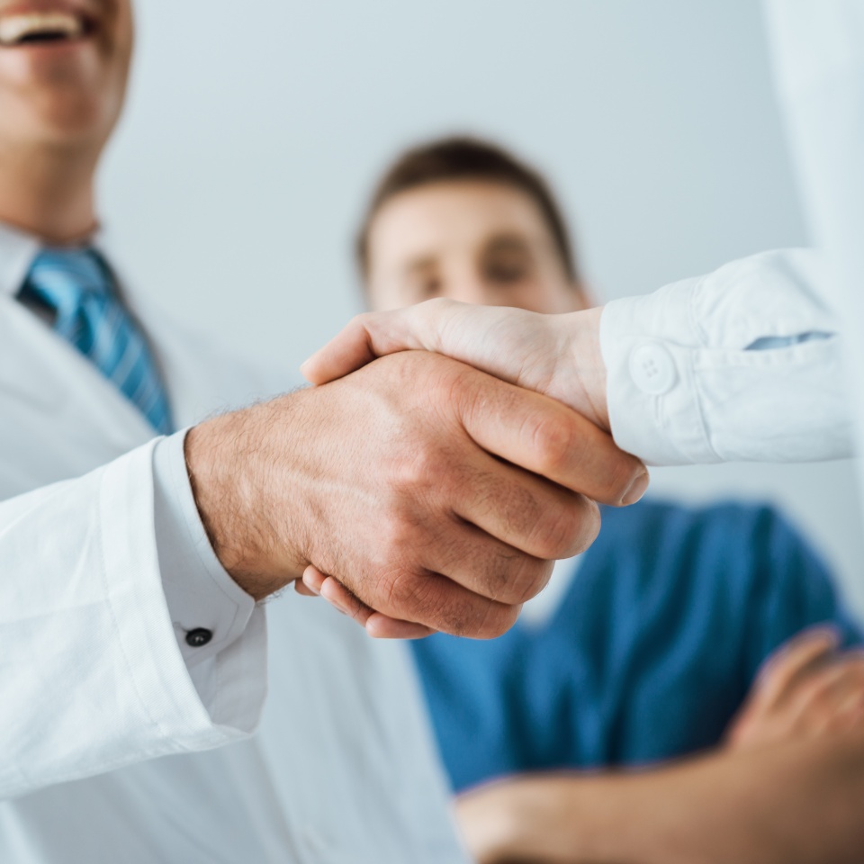 Professional doctors handshaking at hospital hands close up agreement and hiring concept