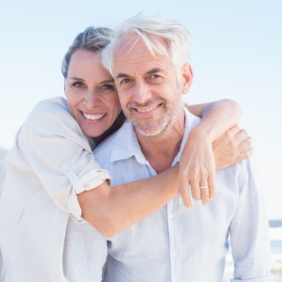 Attractive married couple posing at the beach on a sunny day