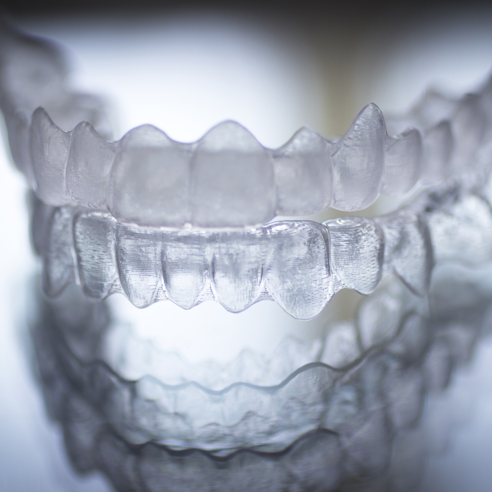 Invisible dental teeth brackets tooth aligners plastic braces retainers to straighten teeth. Orthodontic temporary removable straighteners in dental office dentists surgery clinic.Artistic color photo in creative blue tones. ** Note: Soft Focus at 100%,