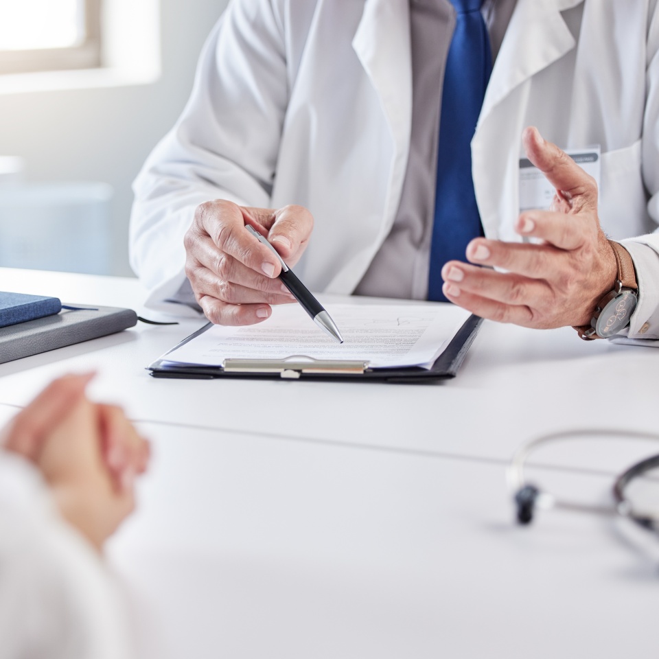 Hands, doctor and patient with consultation in clipboard for medical history, information or report. People, medic and documents for admin, insurance and checklist for healthcare service in hospital