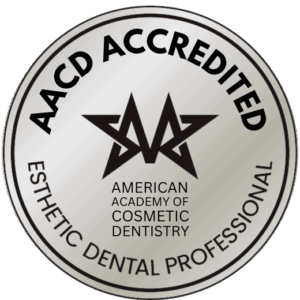 AACD Accredited seal for esthetic dental professionals, featuring the American Academy of Cosmetic Dentistry logo and text in black on a silver circular background.